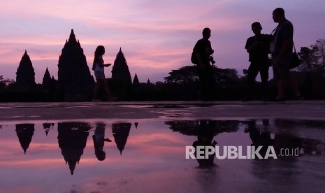 Peserta ajang Mandiri Jogja Marathon dan sejumlah pengunjung menikmati matahari terbit di Kawasan Candi Prambanan, Sleman Yogyakarta, Ahad (23/4).