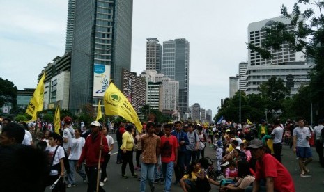 Peserta aksi 412 di tengah-tengah warga yang sedang berolahraga di car free day sepanjang Jalan Sudirman dan MH Thamrin, Jakarta, Ahad (4/12).