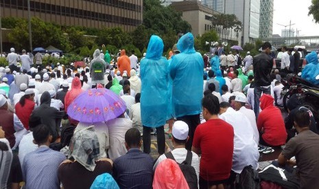 Peserta aksi damai basah kuyup saat mendengarkan ceramah Shalat Jumat.