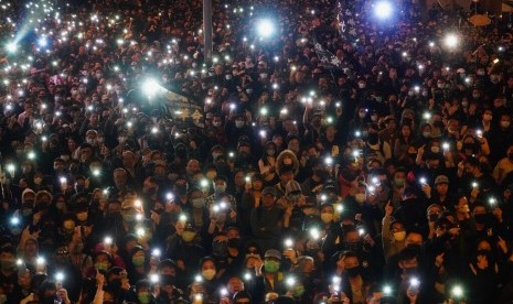 Peserta aksi Hong Kong menyalakan senter dari smartphone mereka saat berkumpul di jalanan Hong Kong, Ahad (8/12). Enam bulan berlalu, aksi demonstrasi Hong Kong masih berlangsung.