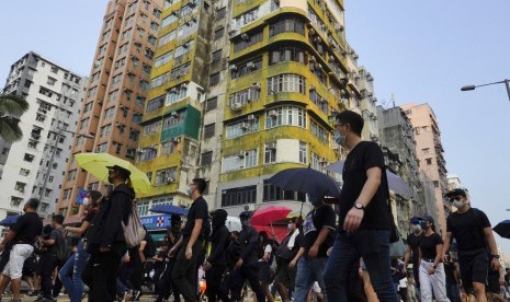 Peserta aksi melakukan long march di Hong Kong, Sabtu (12/10).