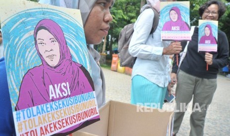 Peserta aksi menunjukkan poster dan kotak donasi pada aksi Tolak Eksekusi Baiq Nuril Maknun di Taman Kamabang Iwak Palembang, Minggu (18/11/2018). 