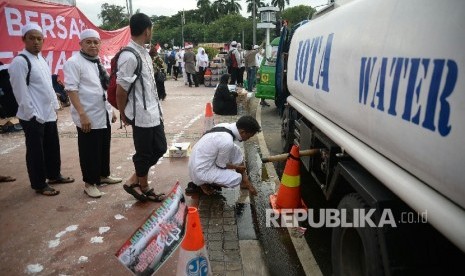  Peserta Aksi super damai 212 mengambil air wudhu sebelum melaksanakan sholat Jumat di Kawasan Silang Monas, Jakarta, Jumat,(2/12)