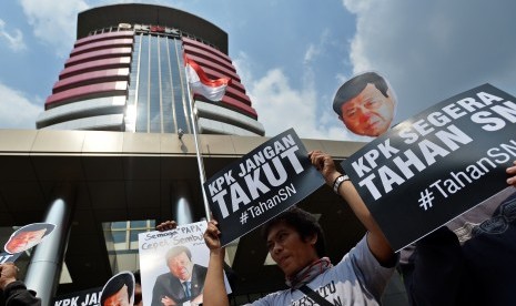 Peserta aksi yang tergabung dalam Koalisi Masyarakat Sipil Antikorupsi membawa poster bergambar Ketua DPR Setya Novanto ketika melakukan aksi di depan Gedung KPK, Jakarta, Kamis (14/9). 