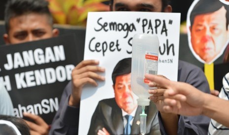 Peserta aksi yang tergabung dalam Koalisi Masyarakat Sipil Antikorupsi membawa poster bergambar Ketua DPR Setya Novanto ketika melakukan aksi di depan Gedung KPK, Jakarta, Kamis (14/9).