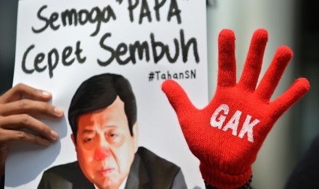 Peserta aksi yang tergabung dalam Koalisi Masyarakat Sipil Antikorupsi membawa poster bergambar Ketua DPR Setya Novanto ketika melakukan aksi di depan Gedung KPK, Jakarta, Kamis (14/9). 