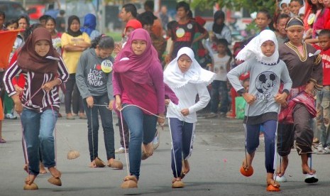 Peserta berpacu sambil menggunakan sandal dari tempurung/batok kelapa atau 