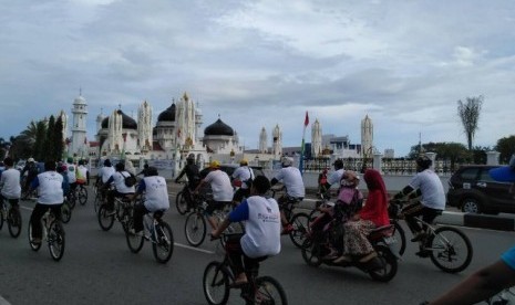 Peserta Gowes Pesona Nusantara melintasi Masjid Baiturrahman Banda Aceh, Ahad (14/5).