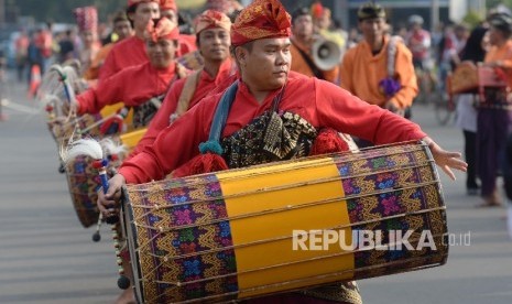  Peserta karnaval budaya Nusa Tenggara Barat (NTB) memainkan gendang Belek saat promosi budaya dan pariwisata Lombok Sumbawa di car free day Jalan Thamrin, Jakarta, Ahad (17/7).  (Republika/Yasin Habibi) 