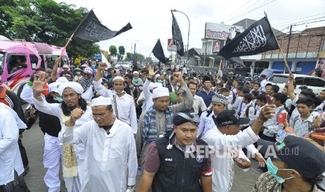 Peserta long march berjalan kaki dalam aksi Bela Islam 212 Jilid III dari Ciamis ke Jakarta di Jalan Raya Rancaekek, Kabupaten Bandung, Rabu (30/11). 