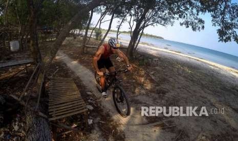 Peserta memacu sepeda ketika mengikuti Rhino Cross Triathlon 2018 di Kawasan KEK Tanjung Lesung, Pandeglang, Banten, Ahad (30/9).