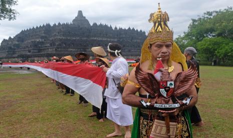 Peserta membentangkan bendera merah putih mengelilingi Candi Borobudur saat peringatan Hari Lahir Pancasila di Taman Wisata Candi (TWC) Borobudur, Magelang, Jawa Tengah, Rabu (1/6/2022). Kegiatan pembentangan bendera sepanjang satu kilometer yang diikuti oleh berbagai elemen masyarakat tersebut sebagai wujud semangat persatuan dan kesatuan bangsa dalam menjaga dasar negara Pancasila. 