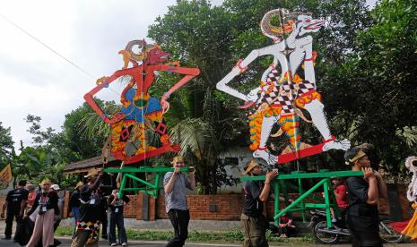 Peserta mengusung wayang berukuran besar saat mengikuti kirab Festival Tresna Wayang Dolanan (cinta wayang mainan) di Desa Wisata Candirejo, Borobudur, Magelang, Jawa Tengah, Jumat (22/7/2022). Kegiatan yang diselenggarakan oleh Kementerian Pendidikan Kebudayaan Riset dan Teknologi bekerja sama dengan pelaku seni di wilayah Borobudur dimeriahkan dengan karnaval wayang, pentas seni dan pelatihan membuat berbagai jenis wayang tersebut bertujuan mengenalkan dan melestarikan seni wayang pada generasi muda. 