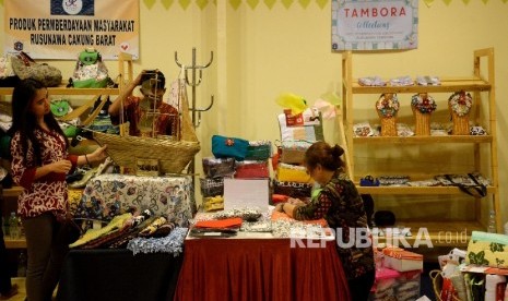 Peserta pameran Ekonomi Kreatif Rusunawa Jakarta (E-Kerja) menata hasil kerajinan ketika mengikuti pameran di Gedung Blok G, Balaikota Jakarta, Rabu (26/4).