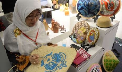 Peserta pameran melukis kerajinan tas pada Pameran Kriyanusa 2018 di Jakarta, Rabu (26/9). Pameran Kriyanusa yang menampilkan karya kreatif kerajinan nusantara tersebut berlangsung hingga 30 September 2018.