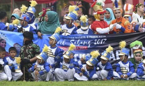 Peserta pawai menyaksikan Genderang Suling Gita Jala Taruna bermain musik saat Kirab Kota dan Pawai Budaya Sail Sabang di Sabang, Aceh, Rabu (29/11).