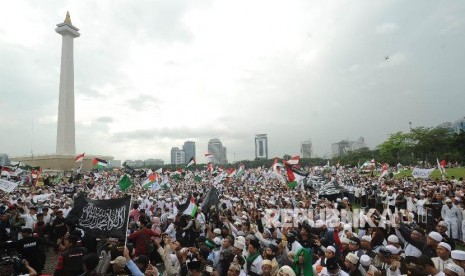 Peserta perempuan aksi solidaritas Palestina mengibarkan bendera dalam aksi solidaritas Palestina di Monumen Nasional, Jakarta, Ahad (17/12).