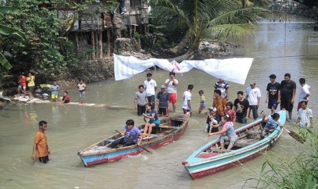 Peserta perempuan sedang memacu kecepatan perahunya di tengah Sungai Kuripan, Kelurahan Kuripan, Kecamatan Telukbetung Barat, Kota Bandar Lampung, Ahad (17/8)