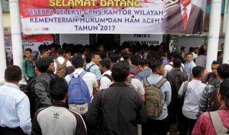 Peserta ujian Calon Pegawai Negeri Sipil (CPNS) Kementerian Hukum dan HAM wilayah Aceh antre seleksi pengukuran tinggi badan di Banda Aceh, Aceh, Senin (11/9).