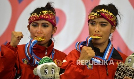 Pesilat Bali Ni Made Dwiyanti dan Sang Ayu Ketut Sidan W menunjukan medali usai tampil dalam final nomor Seni Ganda Putri PON XIX di GOR Graha Laga Satria ITB Jatinangor, Sumedang, Jabar, Sabtu (24/9).