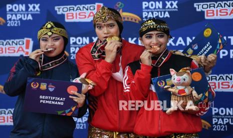 Pesilat putri DKI Jakarta Puspa Arumsari (tengah) bersama pesilat putri Jawa Barat Risya Gunawan (kiri) dan pesilat putri Bali Ni Kadek Astini (kanan) memperlihatkan medalinya saat penyerahan medali Pecak silat kategori Seni Tunggal Putri PON Papua di Gor Toware, Kabupaten Jayapura, Papua, Senin (11/10/2021). Puspa Arumsari berhasil meraih medali emas dengan poin 456 sedangkan medali perak diraih Risya Gunawan dengan poin 453, dan perunggu diperoleh Bali Ni Kadek Astini dengan poin 449. 