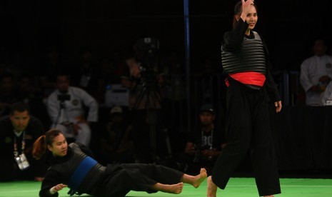 Pesilat putri Indonesia Wewey Wita (kanan) mengangkat tangannya usai menjatuhkan pesilat putri Vietnam Tran Thi Them dalam final tanding kelas B 50-55 Kg putri pencak silat SEA Games XXIX Kuala Lumpur di Stadion Juara, Bukit Kiara, Kuala Lumpur, Malaysia, Selasa (29/8). Wewey berhasil menyabet medali emas setelah mengalahkan Tran Thi Them.