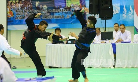 Pesilat Sulawesi Tenggara Rikki Aris Munandar (kiri) berusaha menjatuhkan pesilat Jawa Tengah Muhamad Iqbal (kanan) pada cabang Pencaksilat PON XIX