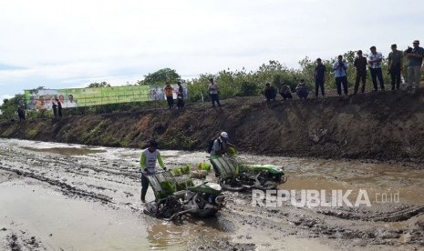 Petani melakukan penanaman padi perdana di lahan cetak sawah baru program 2017 di Desa Tellulimpoe, Kecamatan Marioriawa, Kabupaten Soppeng, Provinsi Sulawesi Selatan, Jumat (17/11).