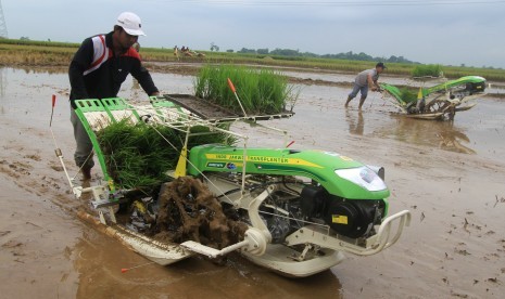 Petani melakukan uji coba mesin penanam padi (transplanter) di areal persawahan Desa Cikedung, Indramayu, Jawa Barat, Rabu (30/3).