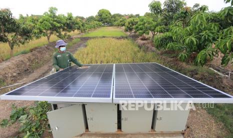 Petani membersihkan permukaan panel surya (solar cell) di area lahan tumpang sari miliknya di Kelurahan Karanganyar, Indramayu, Jawa Barat, Kamis (23/9/2021). Peralihan ke energi bersih dinilai harus diimbangi peningkatan penerimaan masyarakat karena saat ini energi baru terbarukan masih mahal.