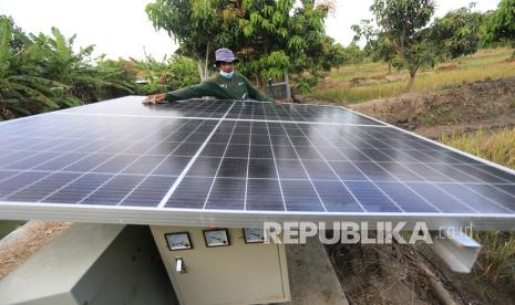 Petani membersihkan permukaan panel surya (solar cell) di area lahan tumpang sari miliknya di Kelurahan Karanganyar, Indramayu, Jawa Barat, Kamis (23/9/2021). Petani memanfaatkan pembangkit listrik tenaga surya sebagai sumber energi lampu penerangan serta menghidupkan pompa air guna mengairi sawah dan kebun palawija.