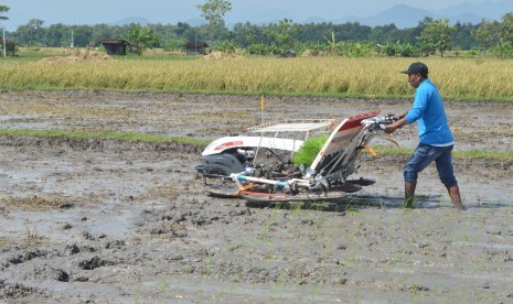 Petani menanam padi menggunakan mesin di Ponorogo, Jawa Timur, Jumat (8/4). 