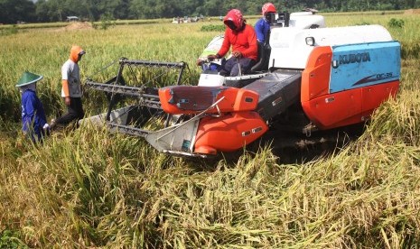 Petani menggunakan mesin pemanen padi untuk mempercepat proses panen di desa Pacing, Ngawi, Jawa Timur, Rabu (24/2)