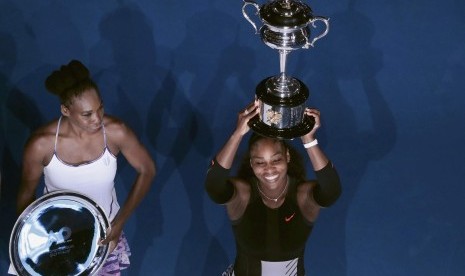 Petenis Amerika Serikat, Serena Williams (kanan) mengangkat trofi Australia Terbuka 2017 setelah mengalahkan Venus Willams pada parta final di Rod Laver Arena, Sabtu (28/1). Serena menang dua set langsung.