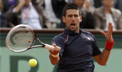 Petenis asal Serbia, Novak Djokovic, mengembalikan bola ke lawannya asal Italia, Andreas Seppi, dalam babak keempat turnamen Prancis Terbuka di Roland Garros, Paris, Ahad (3/6). 