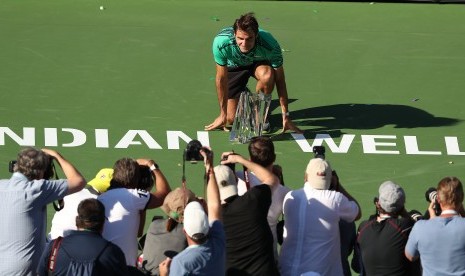 Petenis asal Swiss, Roger Federer berpose bersama trofi Indian Wells Terbuka 2017, Ahad (19/3). Federer mengalahkan Stanislas Wawrinka di partai final.