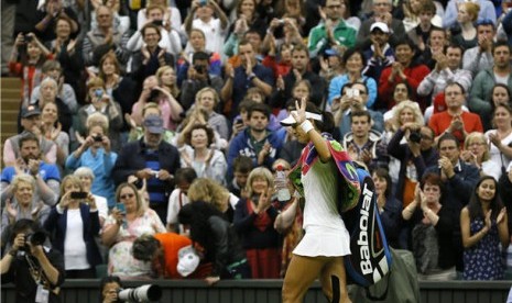 Petenis Cina, Li Na, meninggalkan lapangan sambil melambaikan tangan pada penonton usai takluk dari petenis Polandia, Agnieszka Radwanska, di perempat final Wimbledon di London, Inggris, Selasa (2/7). 