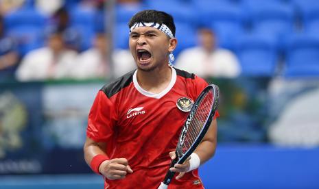 Petenis Indonesia Christopher Rungkat berteriak usai berhasil mencuri poin dari lawannya asal Thailand Yuttana Charoenphon dalam babak final nomor beregu putra tenis SEA Games di Hanaka Paris Ocean Park, Bac Ninh, Vietnam, Ahad (15/5/2022). 