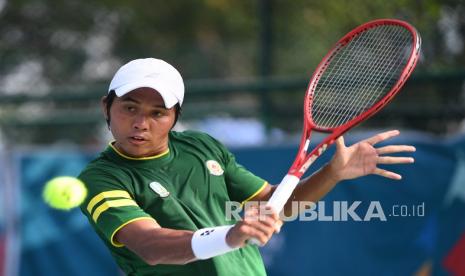 Petenis Jawa Timur M Fifqi Fitriadi mengembalikan bola ke arah lawannya petenis Bengkulu Aditya Hari Sasongko dalam babak final tenis beregu putra PON Papua di Jayapura, Papua, Ahad (3/10/2021). M Rifqi berhasil menang sekaligus memastikan emas bagi Jawa Timur dengan skor 2-0. 