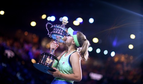 Petenis putri Amerika Serikat (AS) Sofia Kenin mencium trofi juara Grand Slam Australia Terbuka 2020, Sabtu (1/2).