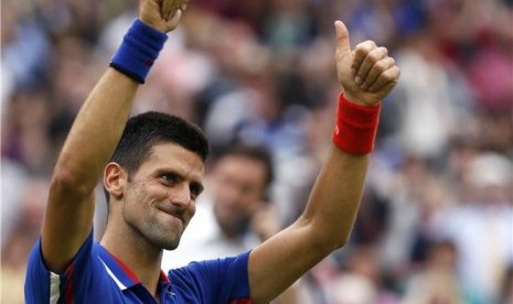 Petenis Serbia, Novak Djokovic, melepaskan senyum merayakan kemenangan usai mengalahkan petenis Amerika Serikat, Andy Roddick, di tenis tunggal putra Olimpiade 2012 di London pada Selasa (31/7).