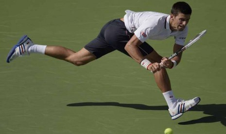 Petenis Serbia, Novak Djokovic, memukul bola pukulan petenis Prancis, Paul Henri Mathieu, di pertandingan turnamen Amerika Terbuka di Flushing Meadows, New York, Amerika, Kamis (28/8). 