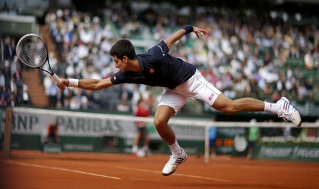  Petenis Serbia, Novak Djokovic, mengembalikan bola pukulan petenis Kanada, Milos Raonic, dalam laga perempat final tunggal putra Prancis Terbuka di Roland Garros, Paris, Selasa (3/6). 