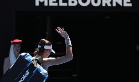 Petenis Spanyol, Garbine Muguruza, melambaikan tangan saat meninggalkan lapangan usai menelan kekalahan dari petenis Taiwan, Hsieh Su-wei, dalam pertandingan putaran kedua turnamen tenis Australia Terbuka di Melbourne, Australia, pada Kamis (18/1). 