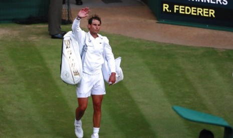 Petenis Spanyol Rafael Nadal melambaikan tangan ke penonton usai bertanding melawan Roger Federer pada semifinal Wimbledon di London, Jumat (12/7) waktu setempat.