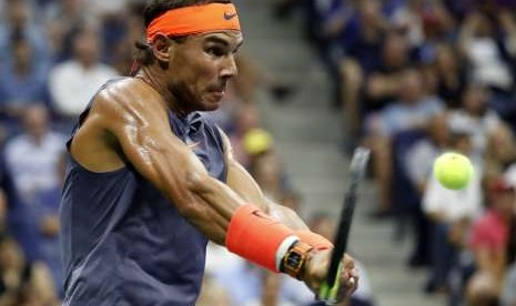 Petenis Spanyol, Rafael Nadal, melepaskan pukulan saat menghadapi petenis Austria, Dominic Thiem, di babak perempat final turnamen AS Terbuka di Flushing Meadows, New York, Amerika Serikat, Selasa (4/9).