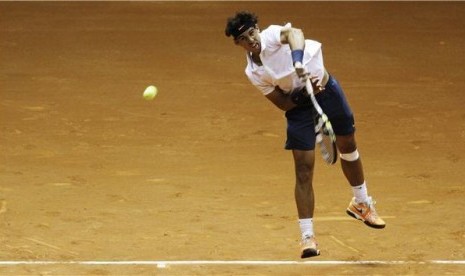 Petenis Spanyol, Rafael Nadal, melepaskan servis saat berduet dengan petenis Argentina, David Nalbandian, menghadapi ganda Spanyol, Pablo Andujar-Guillermo Garcia-Lopez, di turnamen Brazil Terbuka di Sao Paulo, Brazil, Selasa (12/2).  