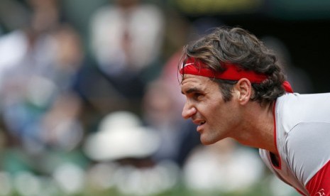 Petenis Swiss, Roger Federer, bersiap menerima servis pemain Slovakia, Lukas Lacko, dalam pertandingan turnamen Prancis Terbuka di Roland Garros, Paris, Sabtu (25/5). 