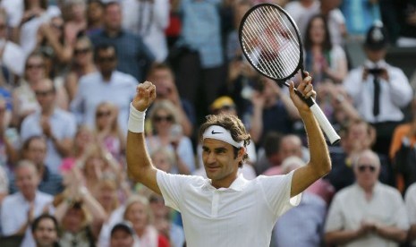 Petenis Swiss, Roger Federer, melakukan selebrasi usai mengalahkan petenis Kanada, Milos Raonic, di babak semifinal Wimbledon di London pada Jumat (4/7). 