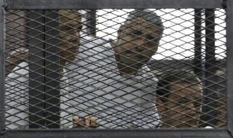 Peter Greste, Mohamed Fahmy and Baher Mohamed (left to right) listen to the ruling at a court in Cairo June 23, 2014.